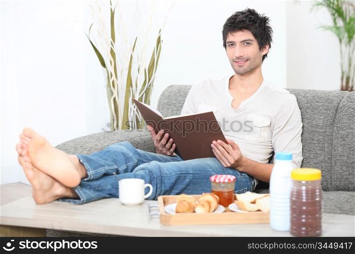 Man reading a book at breakfast