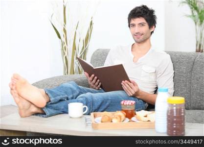 Man reading a book at breakfast