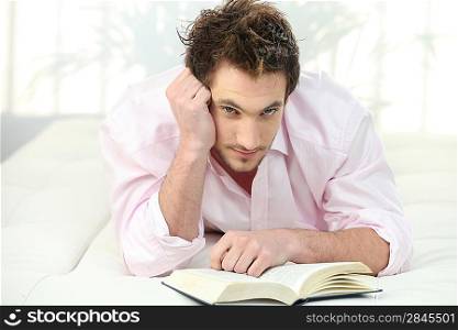Man reading a book in bed