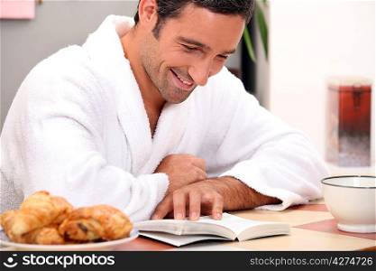 man reading a bookat breakfast