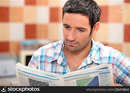 Man reading a journal in the kitchen