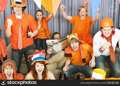 Man, reading a paper, is oblivious of the cheering of the soccer fans around him, when their national team scores.