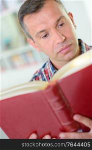 man reading a red book