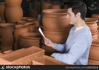 Man reading a shopping list in a garden center