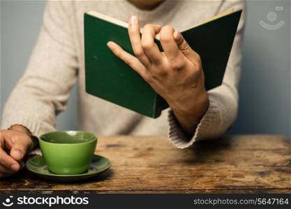 Man reading book and having coffee