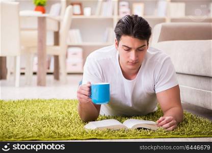 Man reading book at home on floor
