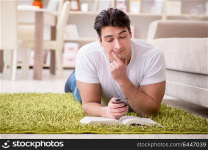 Man reading book at home on floor