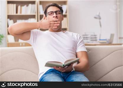Man reading book sitting in couch sofa