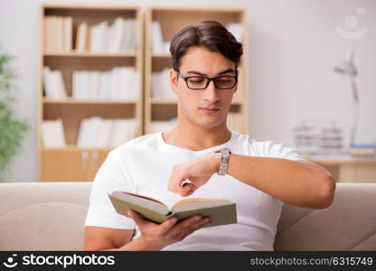 Man reading book sitting in couch sofa