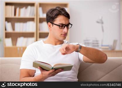 Man reading book sitting in couch sofa