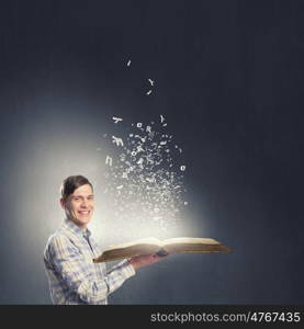 Man reading book. Young student guy with opened book in hands