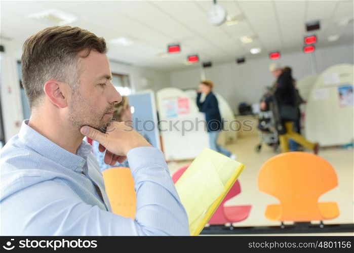 man reading documents while sitting in modern office space interior