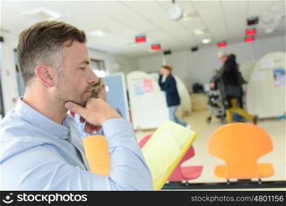 man reading documents while sitting in modern office space interior