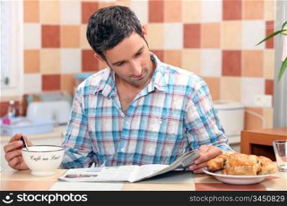 Man reading his newspaper at the breakfast table