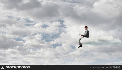 Man reading in isolation. Young businessman sitting on cloud and reading book