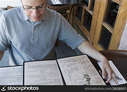 Man reading menu at outdoor restaurant