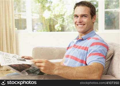 Man Reading Newspaper At Home