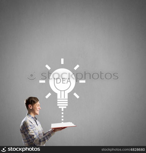 Man reading red book. Young student guy with opened book in hands