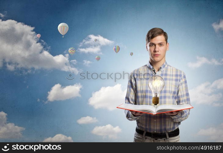 Man reading red book. Young student guy with opened book in hands