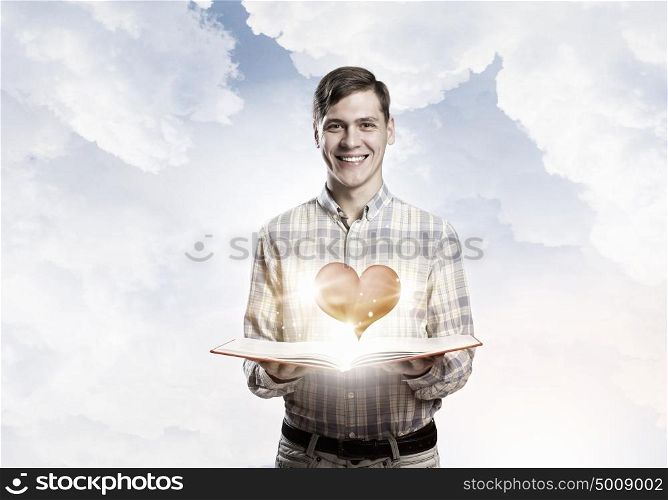 Man reading red book. Young student guy with opened book in hands