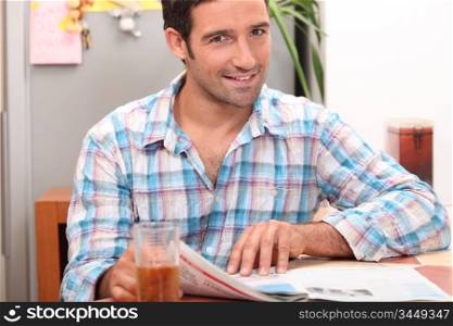 Man reading the newspaper while having a refreshment