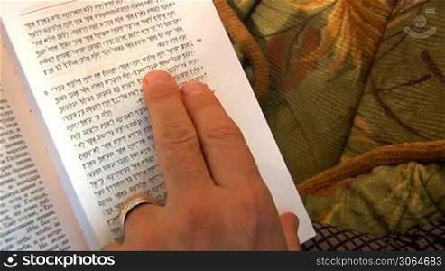 man reads the Torah, leads his finger along the lines