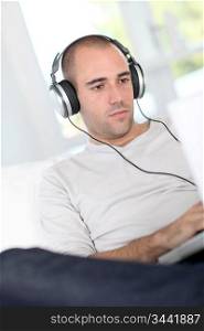 Man relaxing at home with headphones on