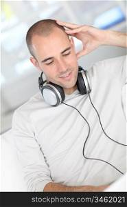 Man relaxing at home with headphones on