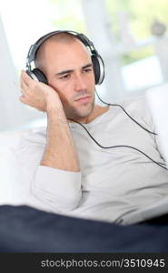 Man relaxing at home with headphones on