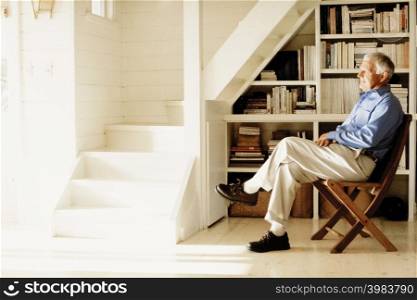 Man relaxing by a bookself