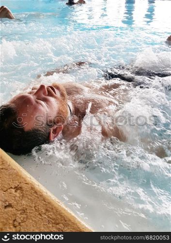 Man relaxing in a spa by the tub