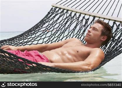 Man Relaxing In Beach Hammock