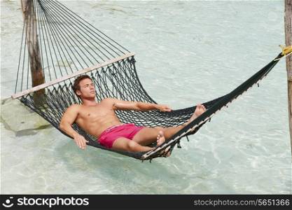 Man Relaxing In Beach Hammock