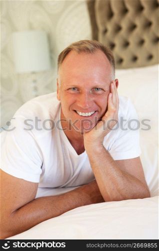 Man Relaxing In Bedroom