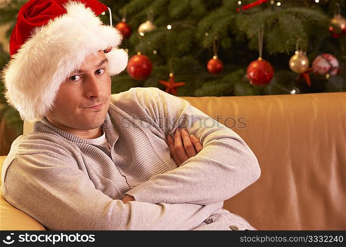 Man Relaxing In Front Of Christmas Tree