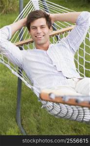Man relaxing in hammock smiling