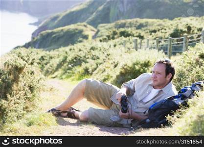 Man relaxing on cliffside path
