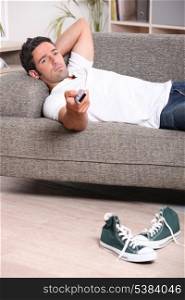 Man relaxing on sofa watching television