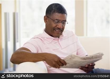 Man relaxing with a newspaper smiling