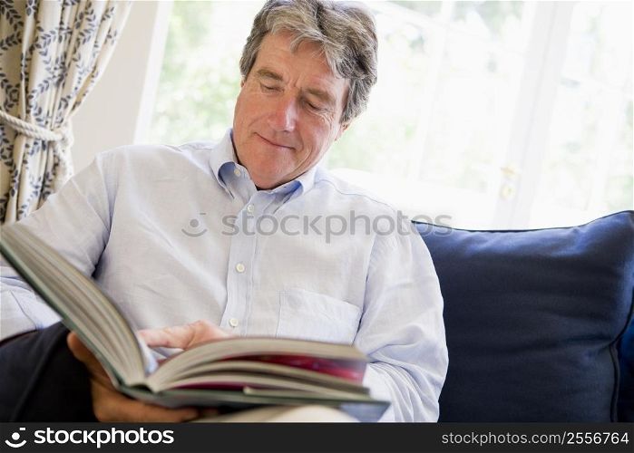Man relaxing with book in living room