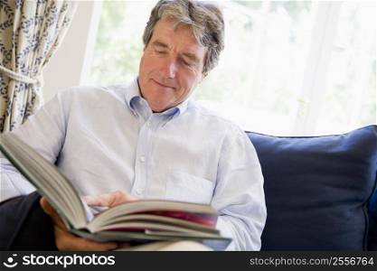 Man relaxing with book in living room