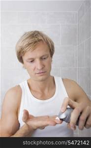 Man removing aftershave moisturizer in bathroom