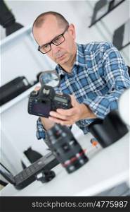 man repairing a camera at his workplace