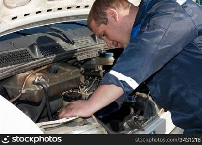 man repairing a car with a raised soot