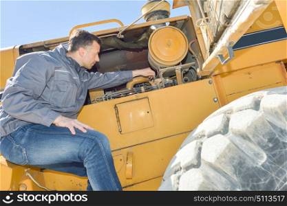 man repairing a combine harvester