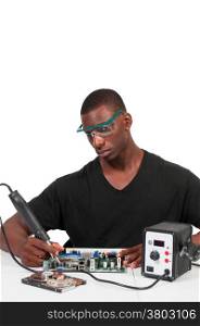 Man repairing a printed circuit board with a forced air soldering iron