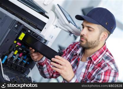 man repairing a printer at work