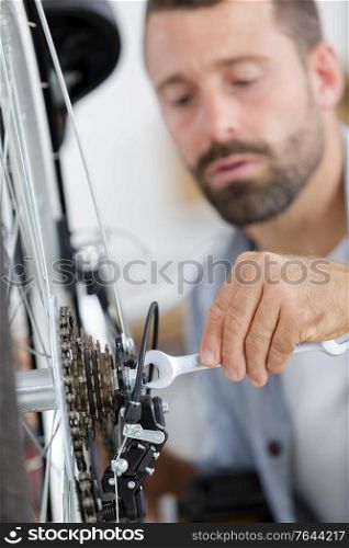man repairing bicycle at home