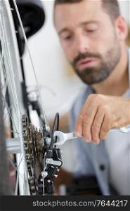 man repairing bicycle at home