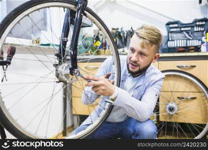 man repairing bicycle tire with wrench